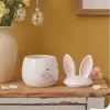 Brûle-parfum en céramique en forme de lapin blanc avec oreilles roses, ambiance déco printanière.