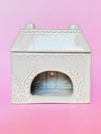 Brûle-parfum en céramique en forme de cottage, vue de dos, avec un design délicat et des motifs floraux sculptés.