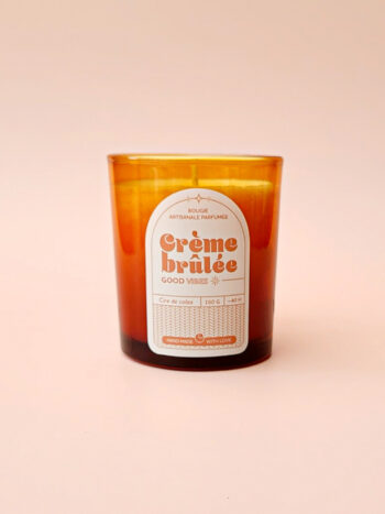 Bougie artisanale parfumée senteur crème brûlée, coulée dans un verre ambré avec une étiquette vintage – une touche chaleureuse et gourmande pour une ambiance cocooning.