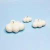 Bougies décoratives en forme de nuages, fabriquées en cire naturelle, disposées sur un fond bleu ciel.