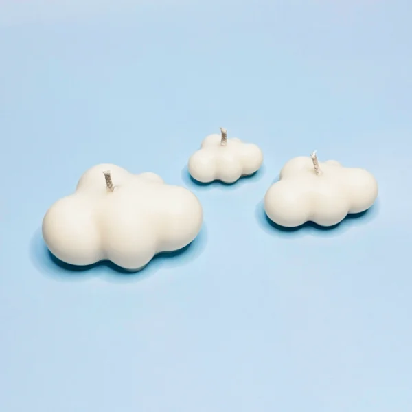 Bougies décoratives en forme de nuages, fabriquées en cire naturelle, disposées sur un fond bleu ciel.
