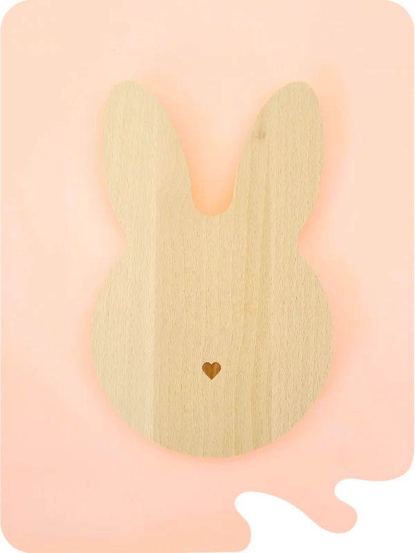 Support en bois naturel en forme de lapin avec petit cœur gravé, conçu pour accueillir bougies décoratives, fondants ou petits accessoires déco, sur fond pastel.
