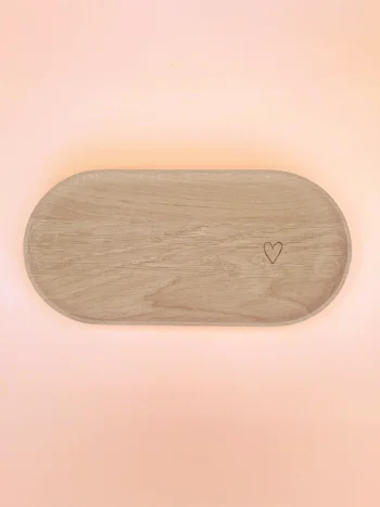 Plateau ovale en bois naturel avec cœur gravé, conçu pour accueillir bougies décoratives, bougies parfumées ou accessoires de décoration, sur fond pastel.