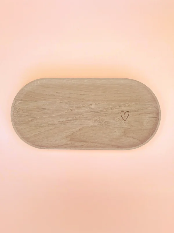 Plateau ovale en bois naturel avec cœur gravé, conçu pour accueillir bougies décoratives, bougies parfumées ou accessoires de décoration, sur fond pastel.