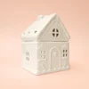 Brûle-parfum Sugar House en céramique blanche, design maison de pain d’épices, vue de trois-quarts sur fond rose.