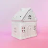 Brûle-parfum Sugar House en céramique blanche, design maison de pain d’épices, vue de trois-quarts sur fond rose.