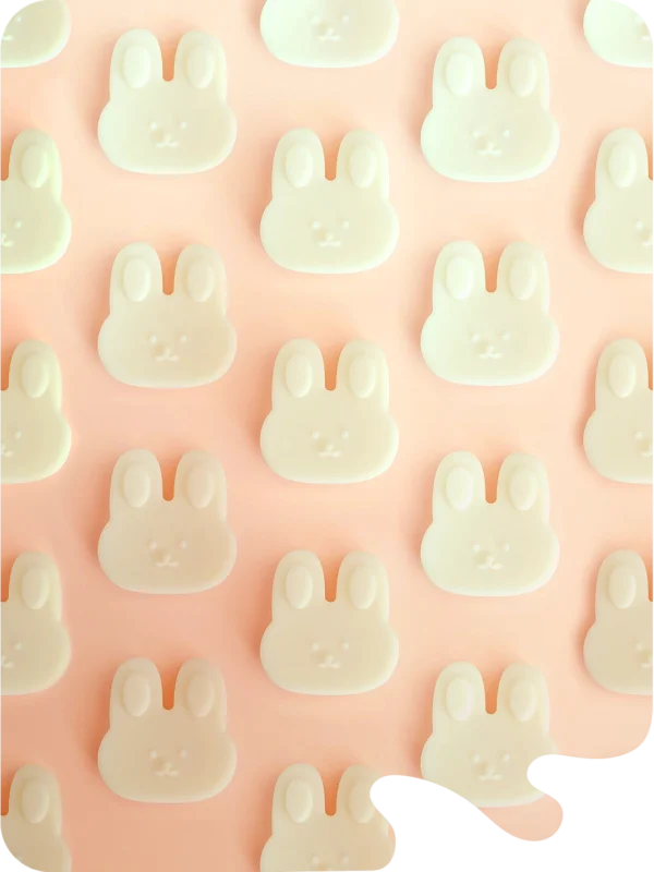 Fondants parfumés en forme de lapin, en cire naturelle, présentés sur fond pastel.