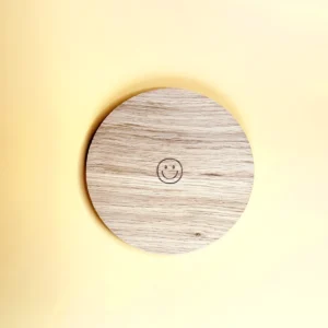 Support en bois circulaire avec une gravure smiley, parfait pour accueillir bougies, petits objets déco et accessoires avec style et bonne humeur.